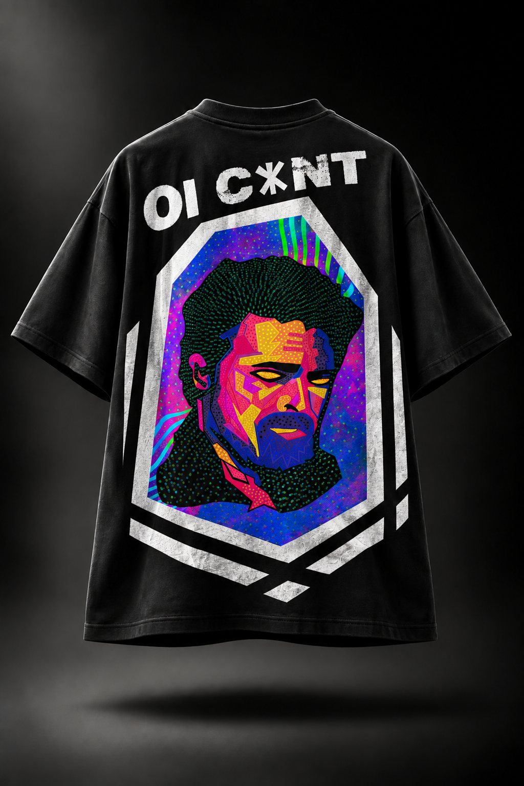 A black oversized LMNO t-shirt featuring a colorful pop-art portrait of a man with the text 'OI C*XNT' printed above it. The graphic is set within a white geometric border on a dark background.